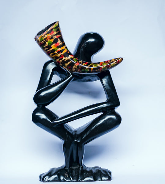 African wood sculpture-Man sitting cross-legged holding a speckled Akan Horn, hand-carved of white wood, Ghana, West Africa 50 cm X 33 cm